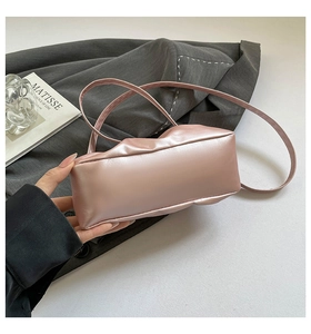 Detail view of the soft pink pleated leather surface and compact cloud-shaped handbag