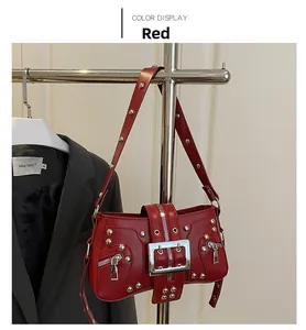 Detail of red punk-style shoulder bag featuring silver rivets and decorative buckle