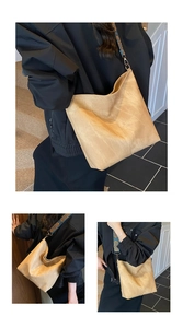 Detail of retro woven wide shoulder strap on a beige suede tote bag with ethnic pattern