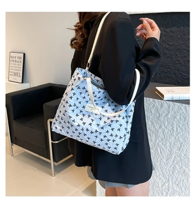 Détail du grand sac cabas matelassé bleu clair avec nœuds noirs et étiquette cuir