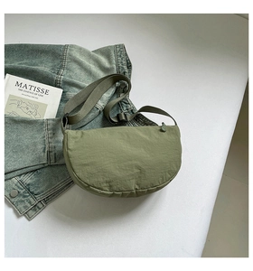 Close-up of grass green nylon half-moon crossbody bag with adjustable strap details