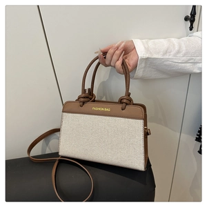 Detail of canvas handbag with brown leather knot straps and Fashion Bag print