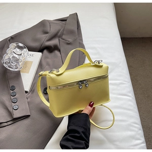 Detail of yellow box bag with dual heart-shaped silver zippers and lychee texture
