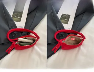 Detail of red suede mini pouch showing interior capacity for lipstick and keys