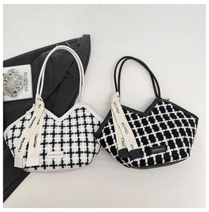 Détail de sacs cabas tissés à carreaux avec étiquettes de mode et rubans décoratifs