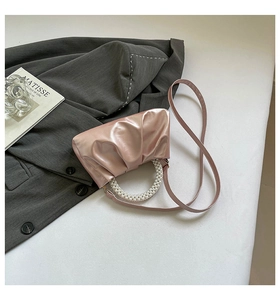 Detailed view of pink pleated mini bag with pearl handle and metallic finish PU leather