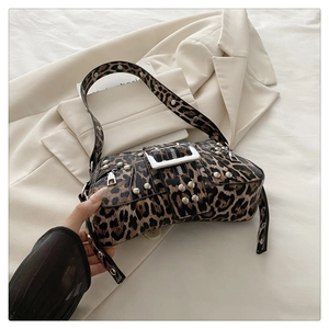 Detail einer Tasche mit Leopardenmuster, Punk-Nieten und dekorativer Metallschnalle