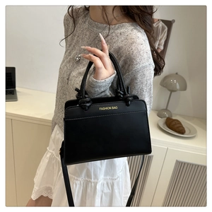 Close-up of black tote bag featuring a knotted handle and Fashion Bag text logo