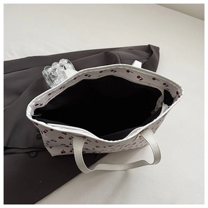 Top view of spacious white cherry print tote bag showing zipper and black lining