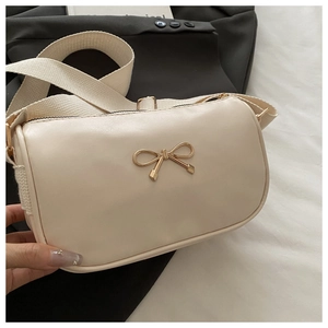 Detailed close-up of cream PU leather crossbody bag with golden bow hardware buckle