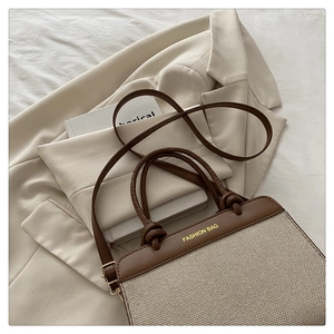 Detail of canvas and brown leather tote with rope knot and Fashion Bag lettering