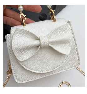 Detail der weißen Mini-Tasche mit Litschimuster, Perlengriff und Schleifendekor