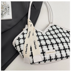 Détail de la texture en tweed pied-de-poule noir et blanc avec étiquette et bandoulière
