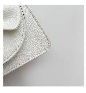 Makroaufnahme der weißen Mini-Tasche aus strukturiertem Leder mit feinen Nähten und Details