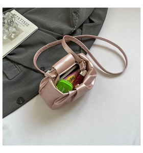 Pink pleated cloud bag detail showing interior storage for phone and lipstick