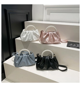Detail of ruched cloud bags in four colors with pearl handles and adjustable straps