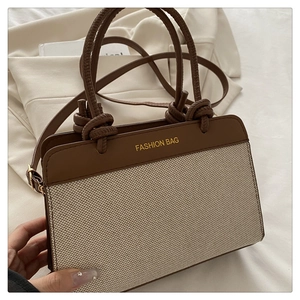 Macro detail of retro woven bag showing contrast leather trim and Fashion Bag logo