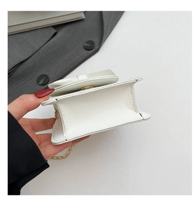Detailansicht der weißen Mini-Tasche mit Litschimuster, Goldkette und Magnetverschluss