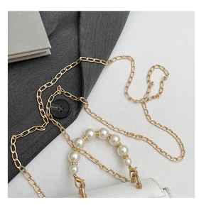 Detailansicht der weißen Tasche mit Lederstruktur, Goldkette und Perlen-Griff