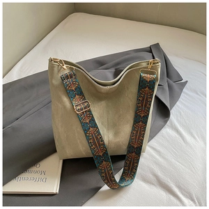 Detail of olive green suede hobo bag featuring ethnic geometric wide shoulder strap
