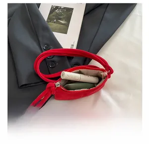Detail view of the red suede mini neck pouch showing lipstick and makeup sponge storage