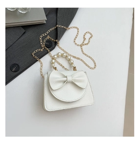 Detailansicht der Mini-Handtasche in Weiß mit Schleife, Perlengriff und goldener Kette