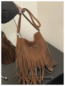 Vue détaillée du sac seau en daim marron avec de longues franges au design bohème