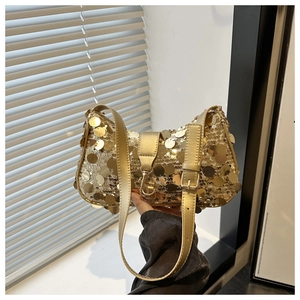 Detail of golden sequin shoulder bag with adjustable leather strap and metallic buckle