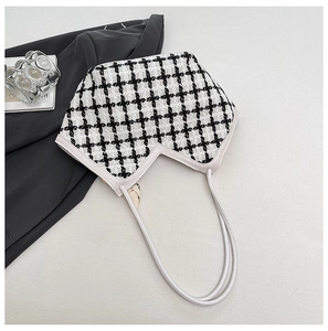 Détail du sac cabas en tweed pied-de-poule avec découpe en V et anses en cuir blanc