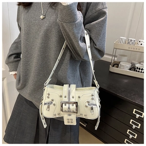 Detail of cream Y2K punk shoulder bag featuring metallic silver studs and buckle strap