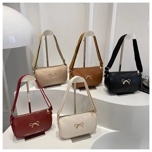 Detail showing high-quality PU leather material and gold bow accent on a crossbody bag