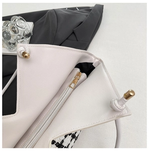 Détail du sac cabas à carreaux avec fermeture zippée et pendentif à nœud blanc