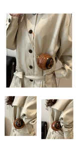 Macro detail of brown 8-ball mini round crossbody bag with gold chain and zipper closure