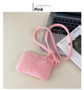 Pink suede mini square neck pouch with stitch details on light desk background