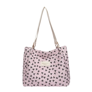Sac fourre-tout matelassé rose avec motifs nœuds noirs et bandoulière de couleur crème