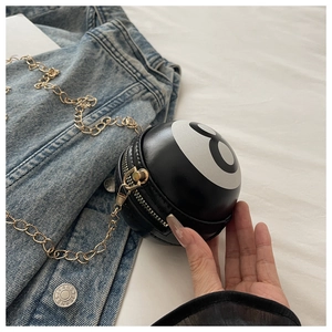 Détail du mini sac boule de billard avec chaîne dorée et logo numéro huit noir