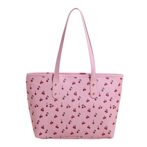 Pink tote bag with cherry print and gold rivets on a minimalist white background
