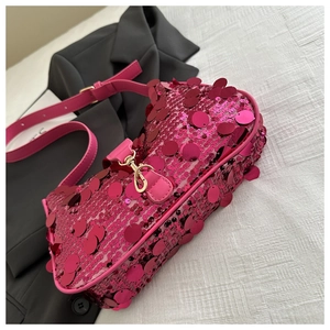 Detailed close-up of pink sequins on a designer shoulder bag with gold metal hardware