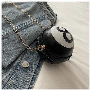 Detail of creative Billiard No. 8 crossbody bag with gold chain on denim jacket