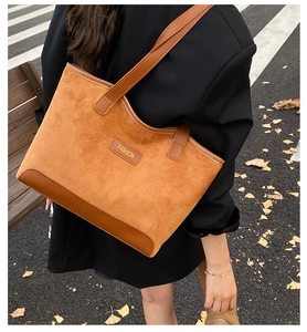 Outdoor shot of a brown oversized tote bag in suede and leather for autumn styling