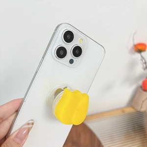 Détail d'un support Griptok tulipe jaune pour téléphone fixé sur un smartphone blanc