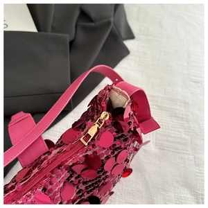 Close-up of pink sequined shoulder bag with gold zipper and leather strap detail