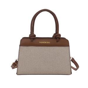 Minimalist canvas tote bag with brown leather handles and adjustable shoulder strap