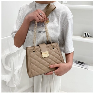 Detailed view of khaki quilted crossbody bag with gold chain strap and metal clasp