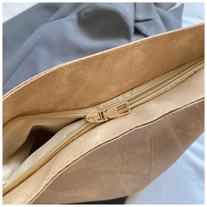 Detail of golden metal zipper and textured camel leather on the large tote bag