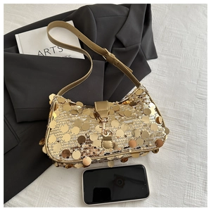Detailed shot of gold sequin underarm bag with leather strap and phone for size scale