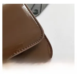 Gros plan sur la texture en cuir verni marron brillant avec coutures précises
