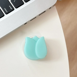 Détail du support de téléphone tulipe bleu clair scintillant sur un bureau moderne
