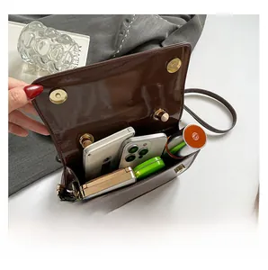 Vue intérieure du sac à bandoulière marron brillant montrant sa grande capacité de rangement