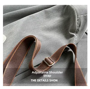 Close-up detail of an adjustable brown woven shoulder strap with metal buckle and stitching